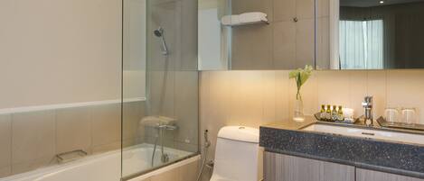 Un baño moderno con ducha envuelta en vidrio, inodoro blanco y tocador con espejo.