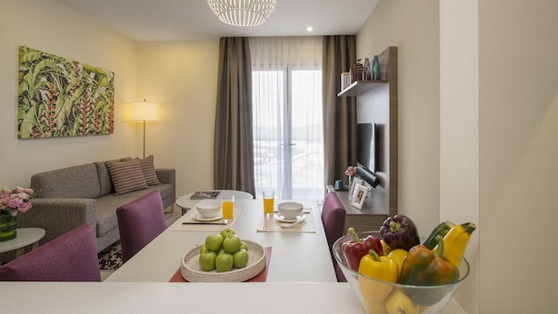 Una sala de estar moderna con un sofá, una mesa de comedor y un frutero.