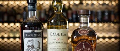 Trois bouteilles de whisky sur une table.