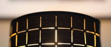 Un gros plan d’une lampe dont l’abat-jour est noir et présente un motif quadrillé.