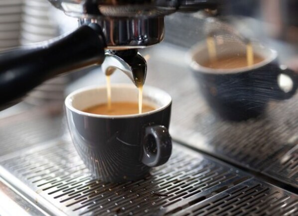 Primer plano de una máquina de café sirviendo un espresso en una taza.