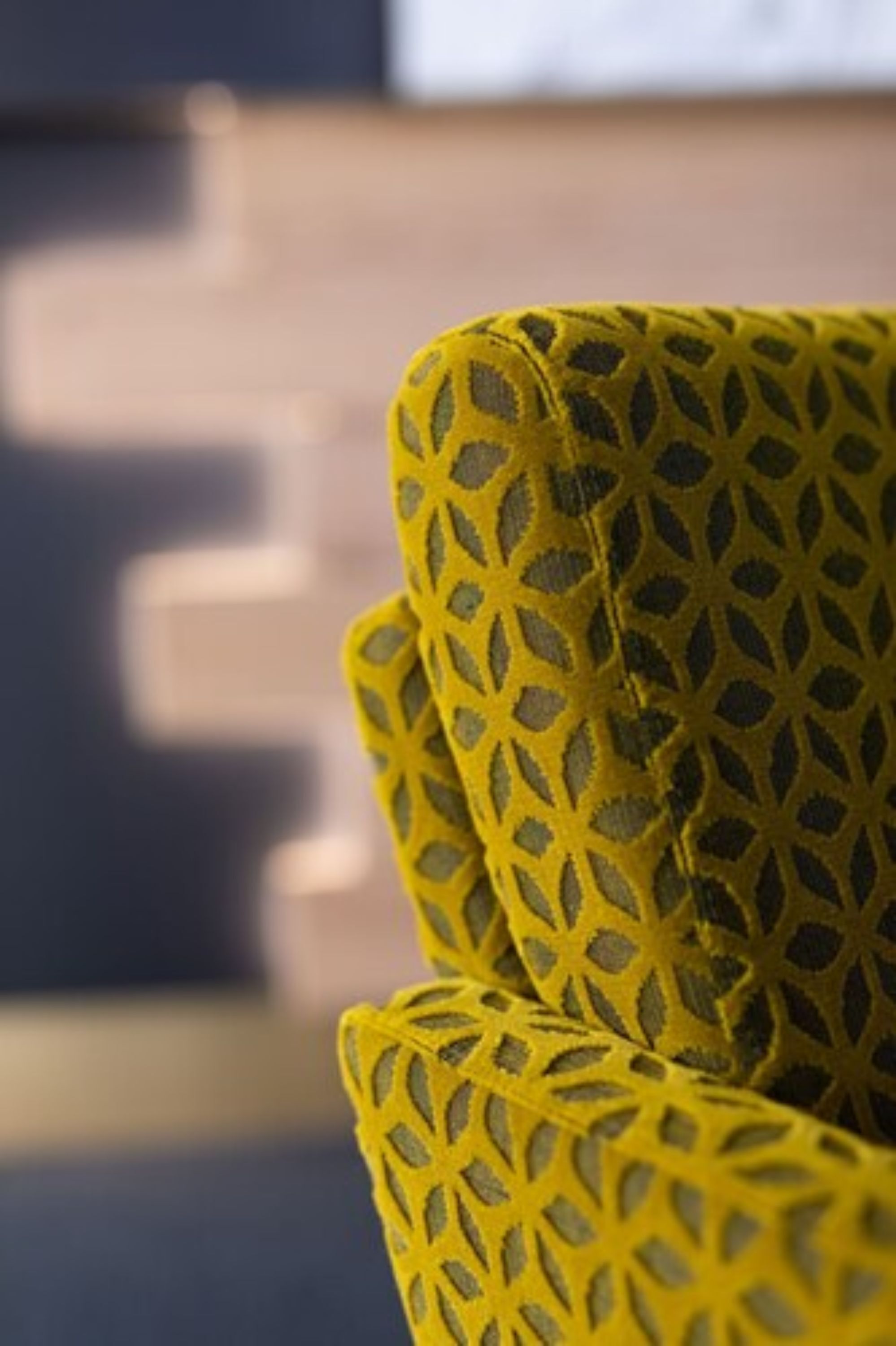 Un gros plan d’un tissu jaune à motifs, qui pourrait faire partie d’un meuble.