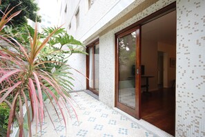 A tiled exterior with a sliding glass door leading to an interior space. - Gomide SP 21 (São Paulo)