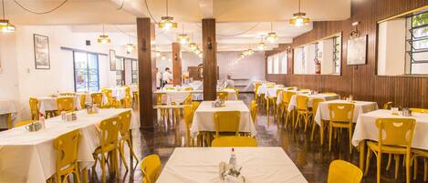 Un restaurant doté de nombreuses tables et chaises, avec une allée centrale.