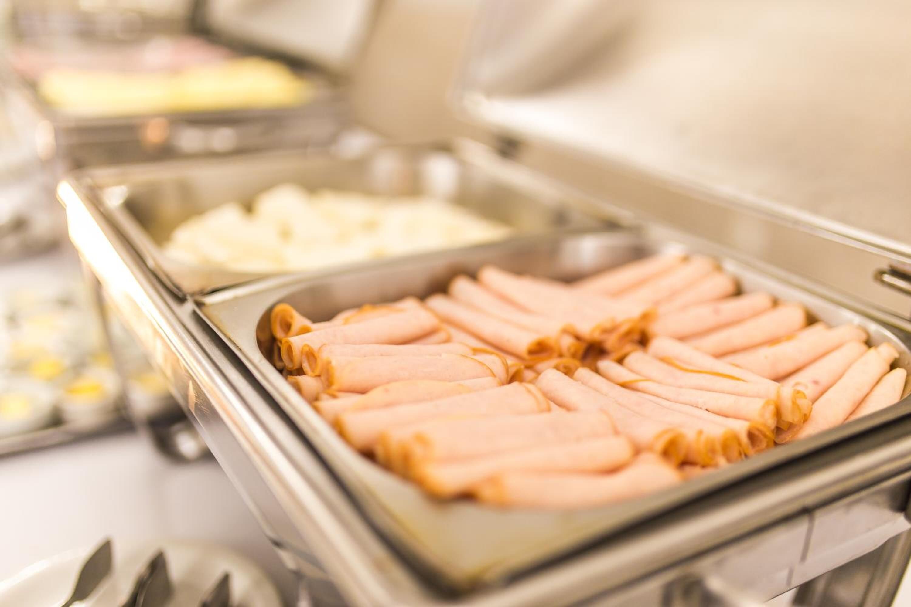 A buffet with various food items, including sliced meats and other dishes.