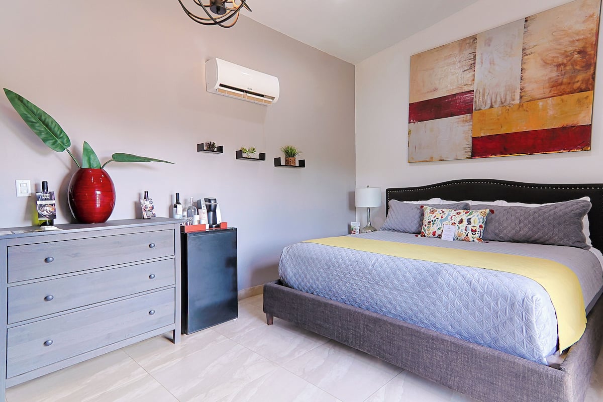 Ein Schlafzimmer mit Bett, Schminktisch und Wandklimaanlage.