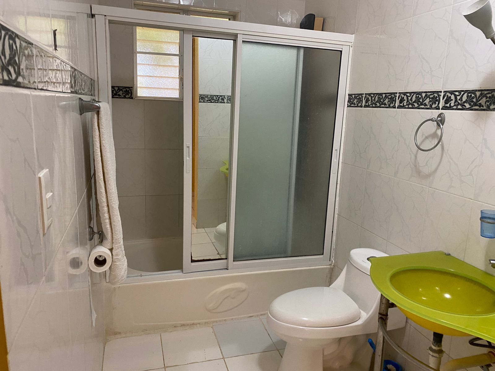 A bathroom with a shower enclosure, toilet, and sink.