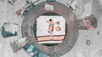 A circular room with a central bed, a circular window, and a patterned floor.