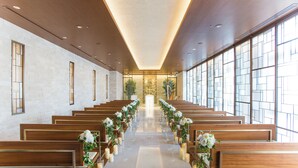 A church interior with wooden pews, a central aisle, and large windows. - Hotel Nikko Tachikawa Tokyo (Tachikawa)