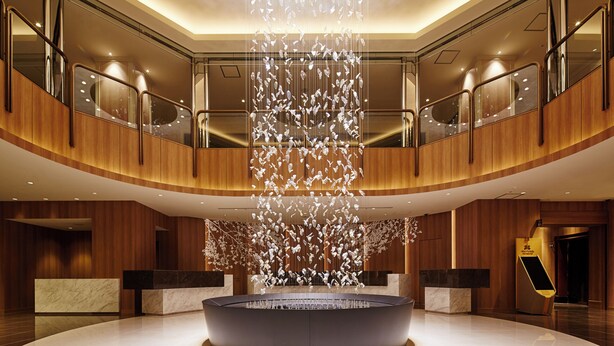 A spacious lobby with a central water feature, wooden paneling, and a reception desk. - Hotel Nikko Tachikawa Tokyo (Tachikawa)