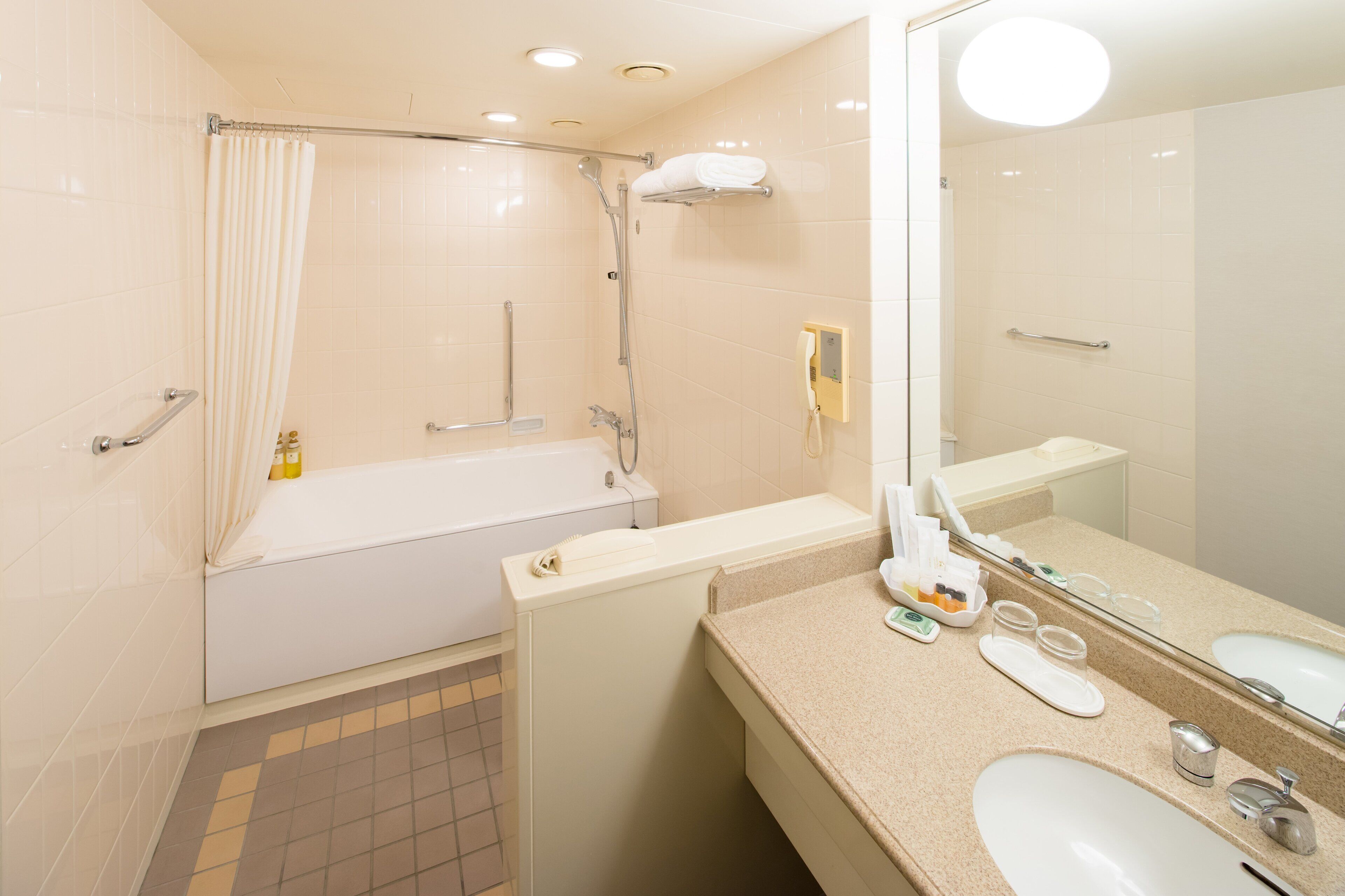 A modern bathroom with a bathtub, a shower, a sink, and a large mirror.