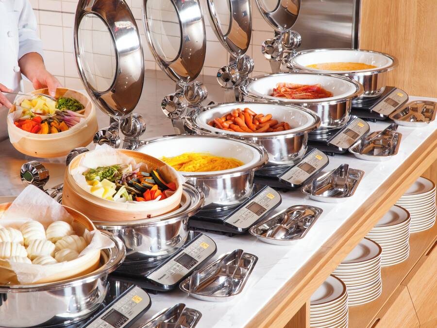A buffet with various food items and weighing scales.