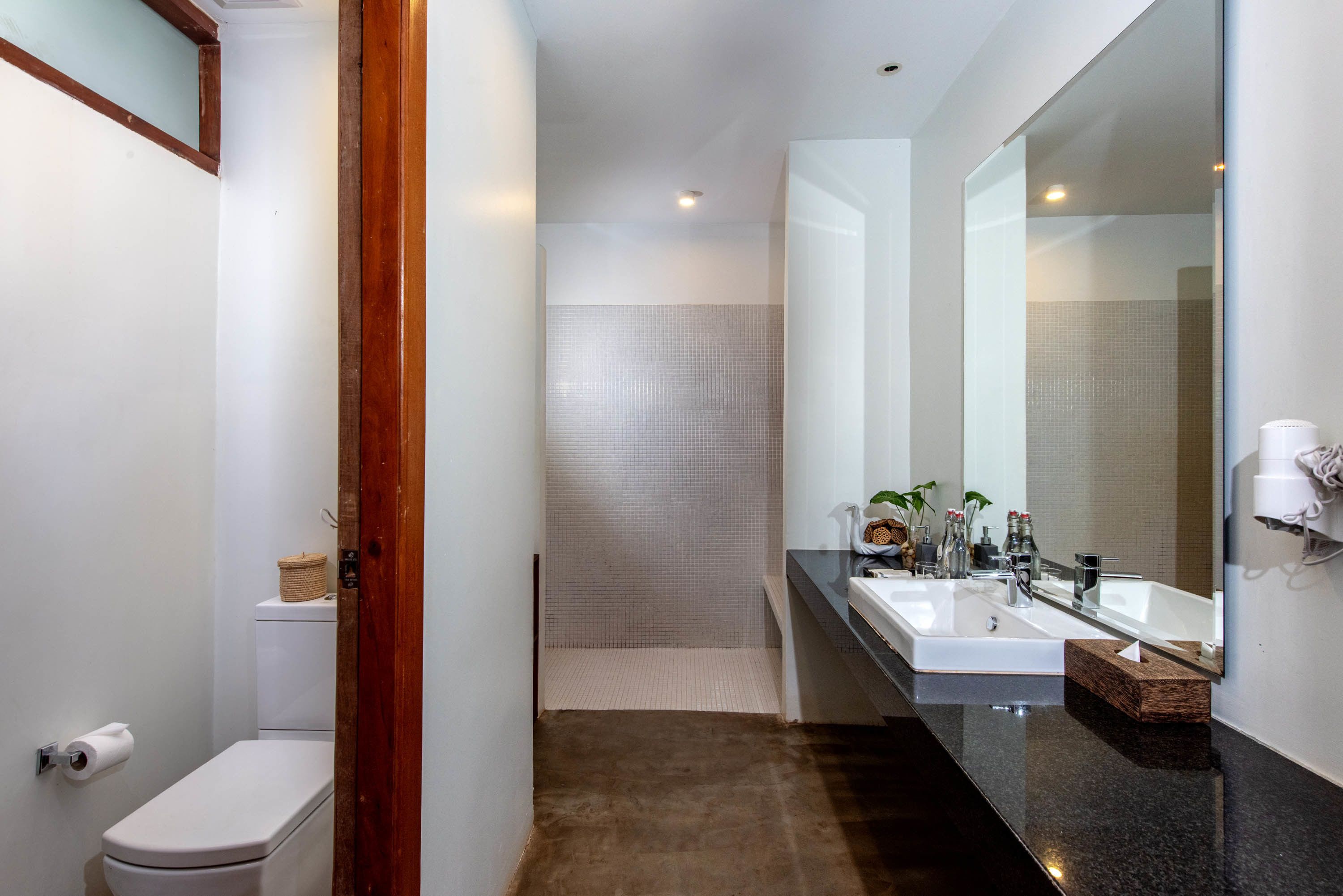 A modern bathroom with a toilet, bidet, and a large mirror.