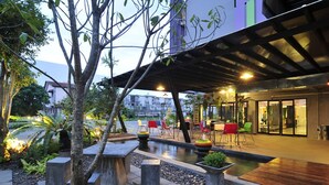 Un espace extérieur aménagé en terrasse, avec des sièges et un petit élément décoratif aquatique.