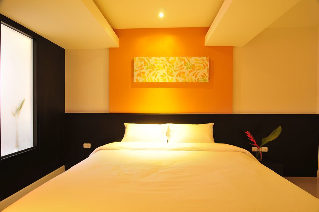 Quarto de hotel moderno com uma cama grande, uma obra de arte na parede e uma janela com vista.