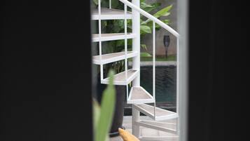 Un intérieur moderne avec un escalier, un canapé et une vue sur un jardin.