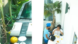 A poolside area with a wooden deck, a white lounge chair, and a yellow spherical object. - Arthur&Paul - Caters to Men (Phnom Penh)