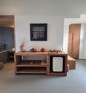 A modern kitchen with a wooden table, a refrigerator, and a wall-mounted picture. - Zen Hideaway@Jeju (Seogwipo)