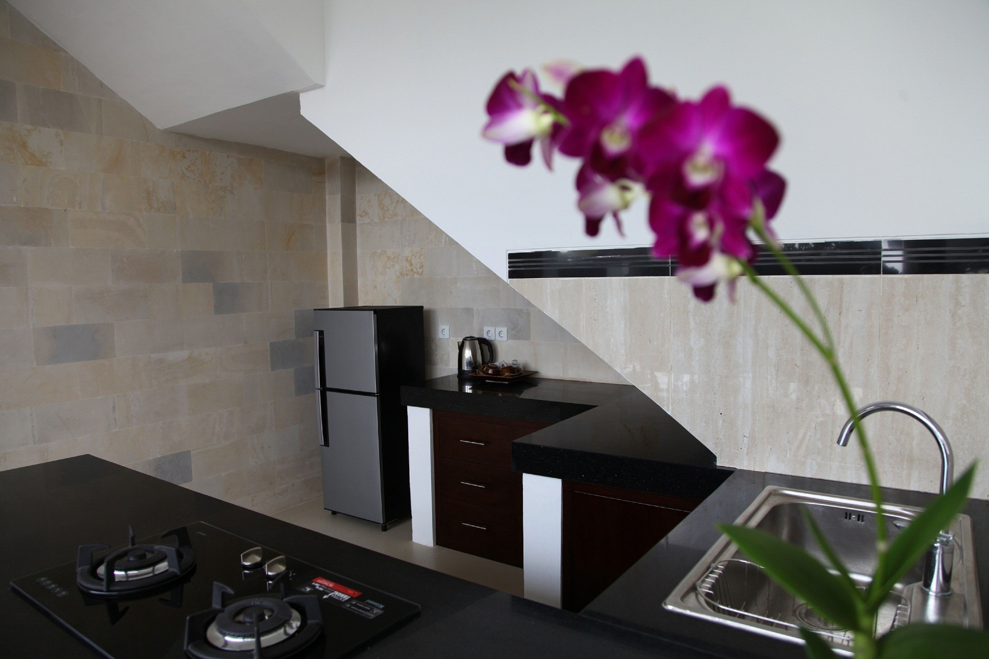 A modern kitchen with a gas stove, a refrigerator, and a sink.