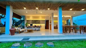 Un espacio de sala de estar moderno y abierto, con cocina, comedor y bar.