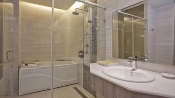 A modern bathroom with a glass-enclosed shower, a freestanding bathtub, and a vanity with a sink and mirror.