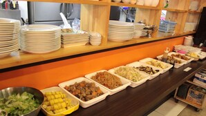 A buffet line with various food dishes and stacked plates. - CVS Bay Hotel (Ichikawa)