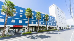 A hotel with a blue facade, palm trees, and a sign reading "CIS Ray Hotel". - CVS Bay Hotel (Ichikawa)