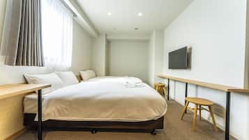 Une chambre d’hôtel équipée d’un lit, d’un bureau, d’une chaise, d’une télévision et d’une fenêtre avec des rideaux.