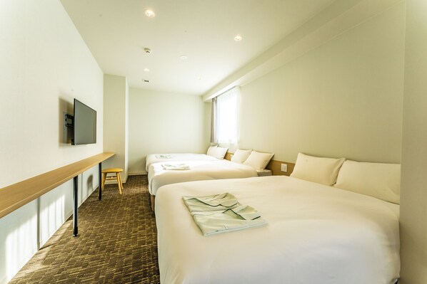 A hotel room with two beds, a TV mounted on the wall, and a wooden bench. - CVS Bay Hotel (Ichikawa)