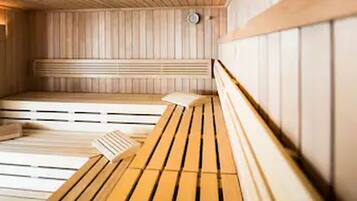A sauna with wooden benches and a sloped floor.