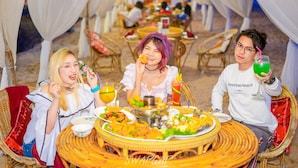A dining setup with wicker chairs and a round table, surrounded by white drapes. - Saint Tropez Beach Resort Hotel (Tha Mai)
