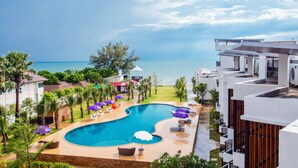 A resort with a swimming pool, palm trees, and a view of the ocean. - Saint Tropez Beach Resort Hotel (Tha Mai)