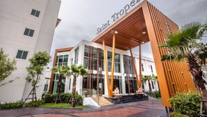 A modern building with a prominent entrance, large windows, and a name sign. - Saint Tropez Beach Resort Hotel (Tha Mai)