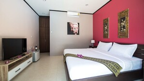 A hotel room with a bed, a TV, a wardrobe, and artwork on the walls. - Ma Maison Phuket (Choeng Thale)