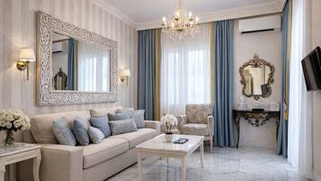 Una sala de estar con sofá, sillón, mesa de centro y un espejo grande.