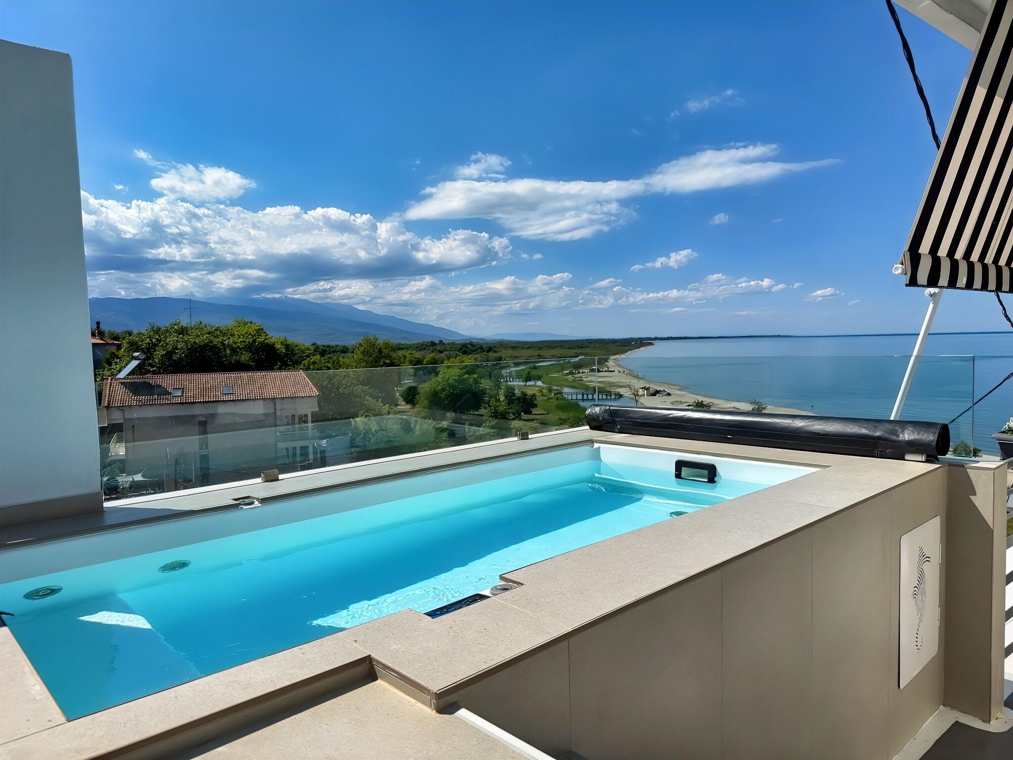 En pool på taket med fri utsikt över havet och bergen.