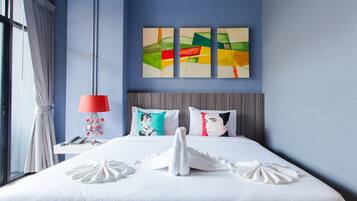 A hotel room with a bed, a nightstand, a lamp, and a window with curtains.
