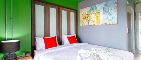 Una habitación de hotel con una cama, un cuadro en la pared y un teléfono en la mesita de noche.