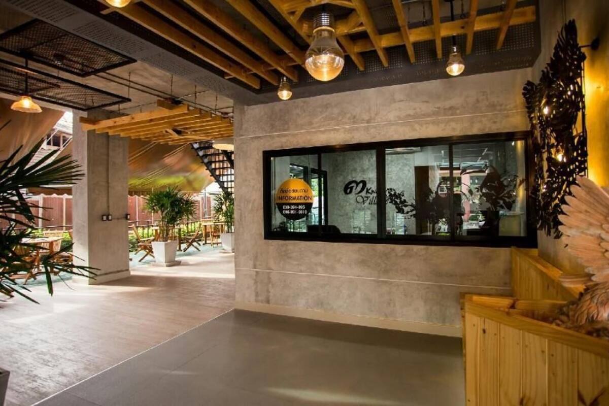 A modern interior with a reception desk, wooden ceiling, and potted plants.