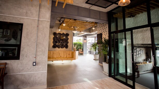 A modern interior with a reception desk, wooden beams, and a glass partition. - 3 Kwan Village (Chonburi)