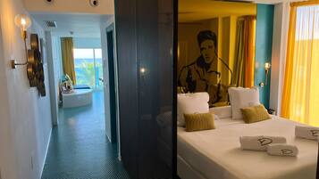 A hotel room with a bed, a large mirror, a ceiling fan, and a view of the outdoors.