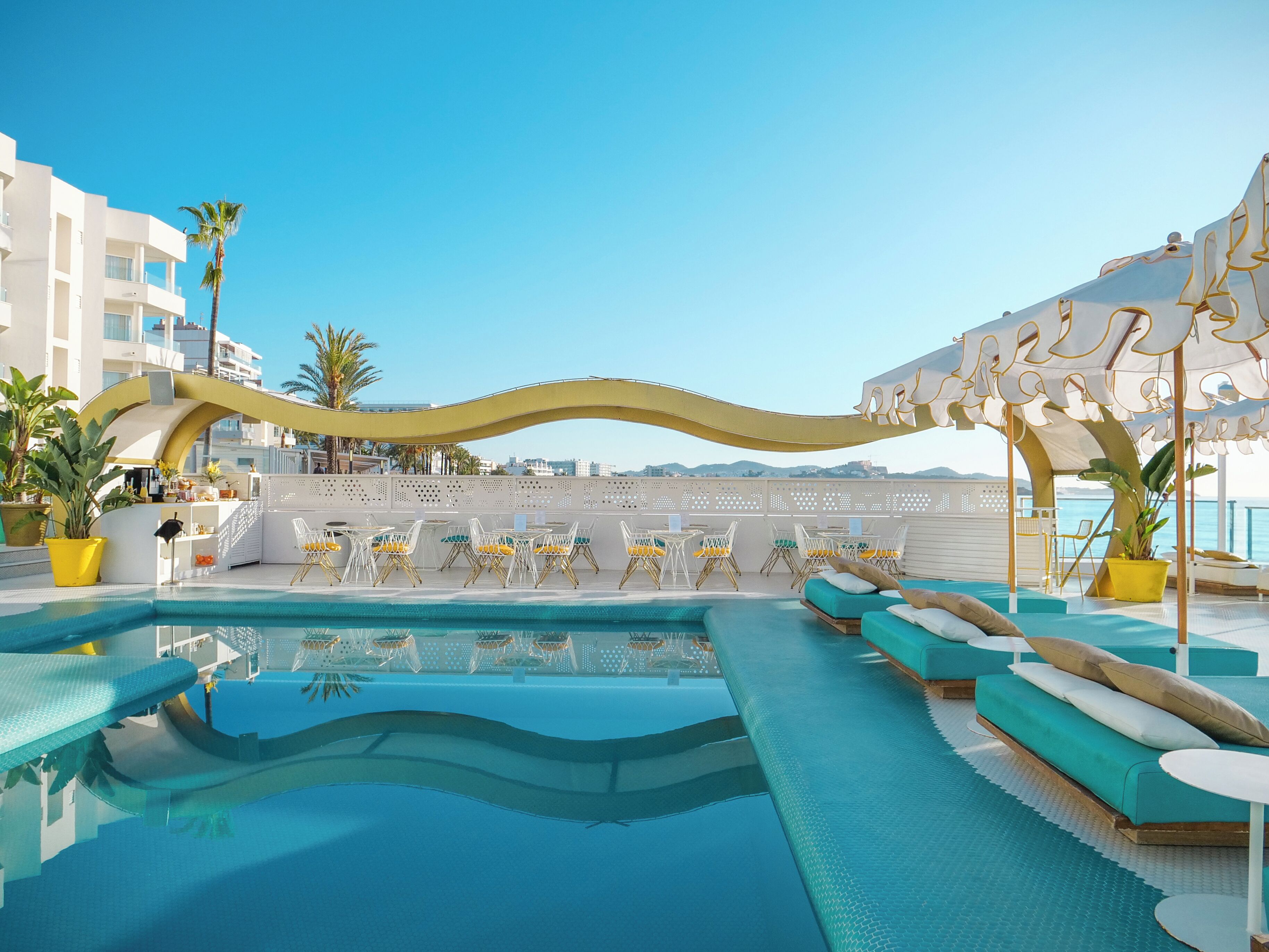 Una piscina al aire libre, sombrillas, tumbonas