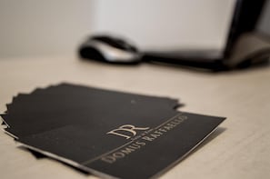 A black folder with gold lettering on a wooden surface. - Domus Raffaello suite in Rome (Rome)