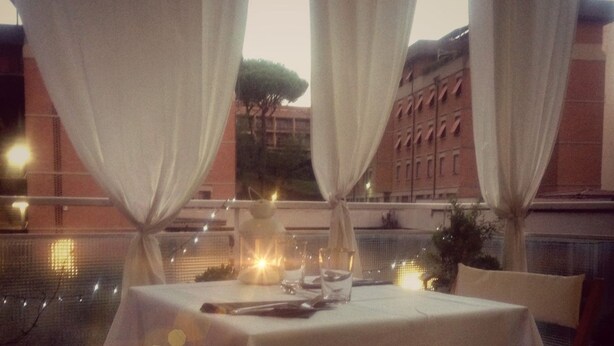 A table set for dining with a view of a building and trees in the background. - Domus Raffaello suite in Rome (Rome)