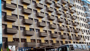 Un edificio de hotel con fachada moderna, varios balcones y un letrero que indica que se trata de un hotel.