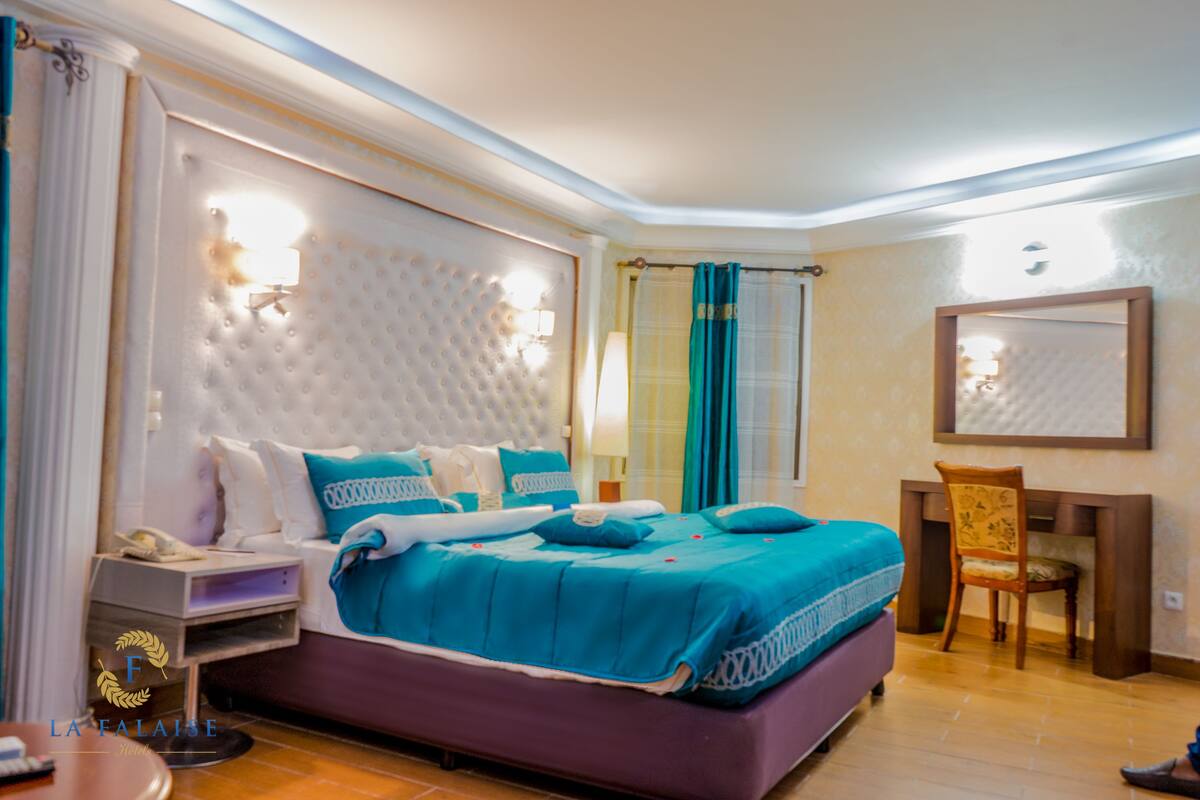 A bedroom with a large bed, a desk, and a chair.