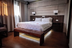 Un dormitorio moderno con una cama de madera, un banco y una mesita de noche.