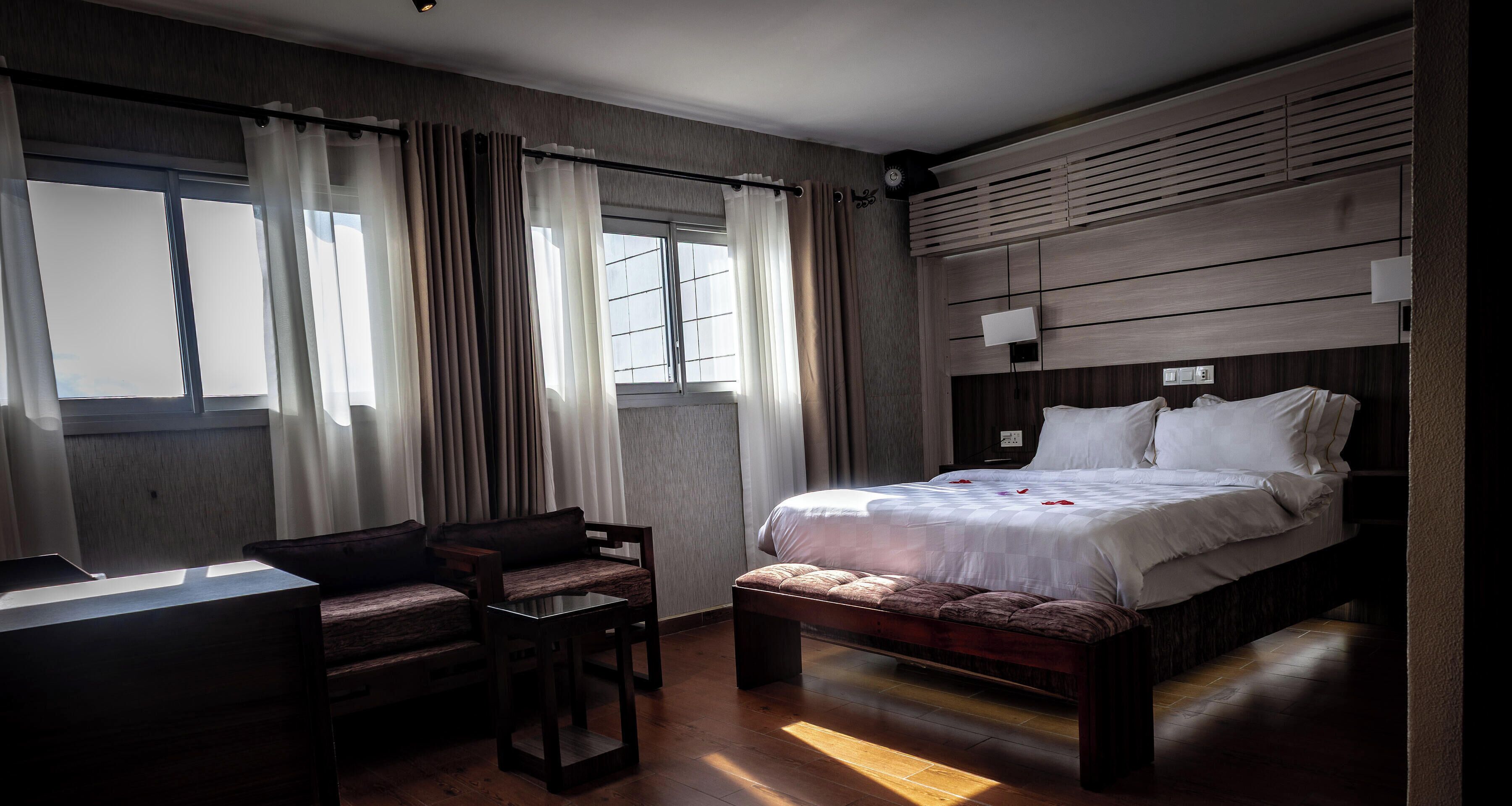 Une chambre d’hôtel avec un lit, un bureau et une chaise.