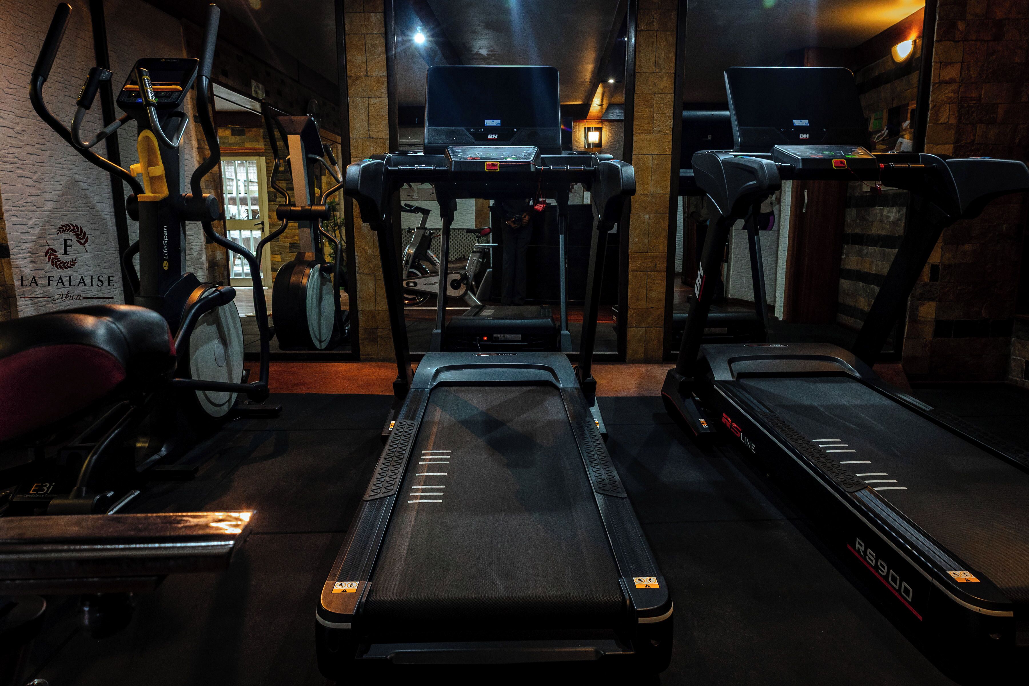 Un gimnasio con cintas de correr, bicicletas estáticas y elípticas.