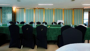 Un salón de conferencias con una mesa larga, sillas y una pared a rayas.